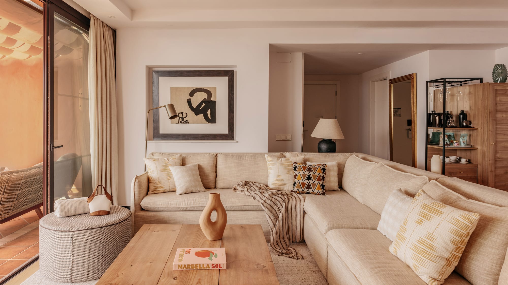 Neutral modern living room with large sectional sofa, coffee table, and art.