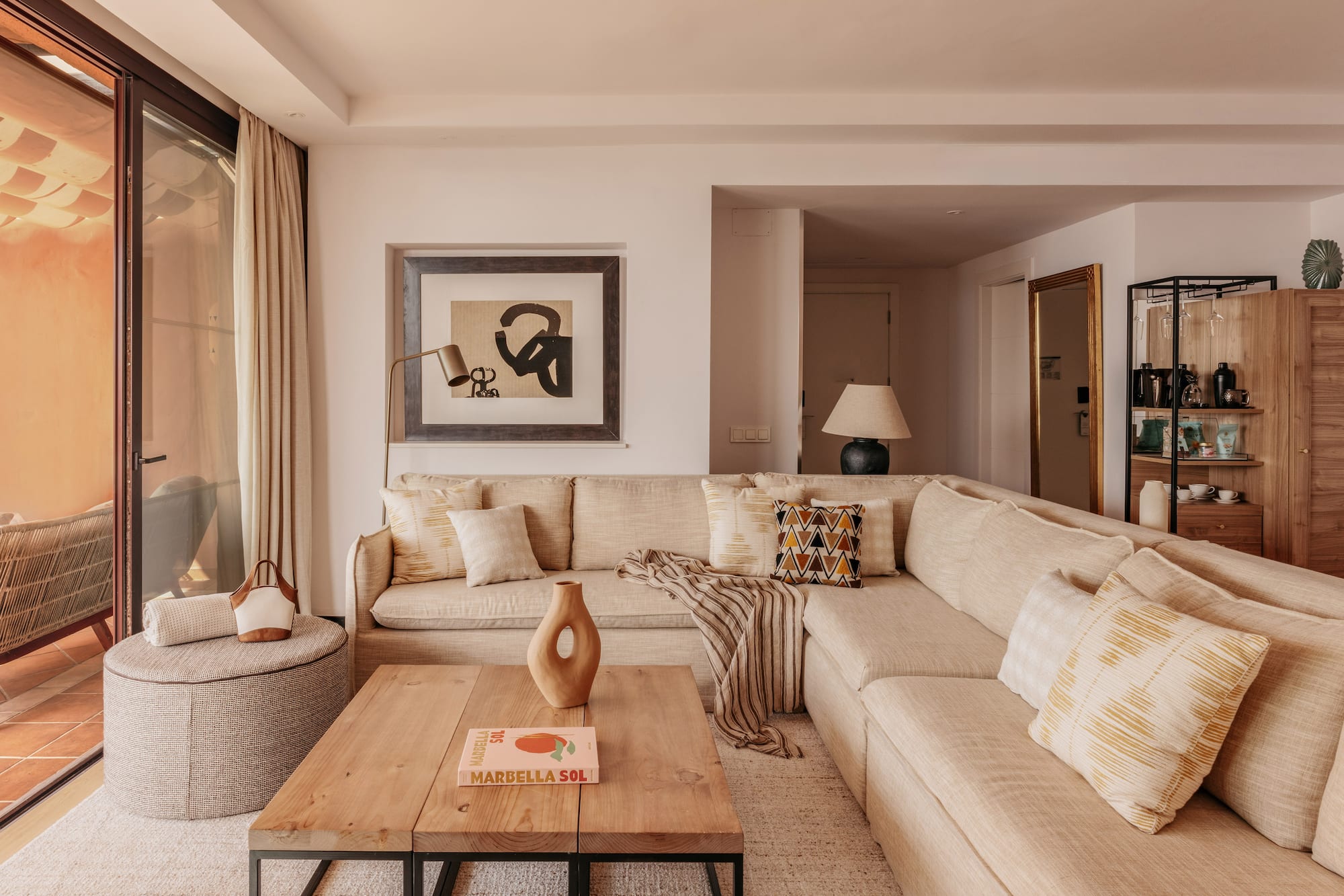 Neutral modern living room with large sectional sofa, coffee table, and art.