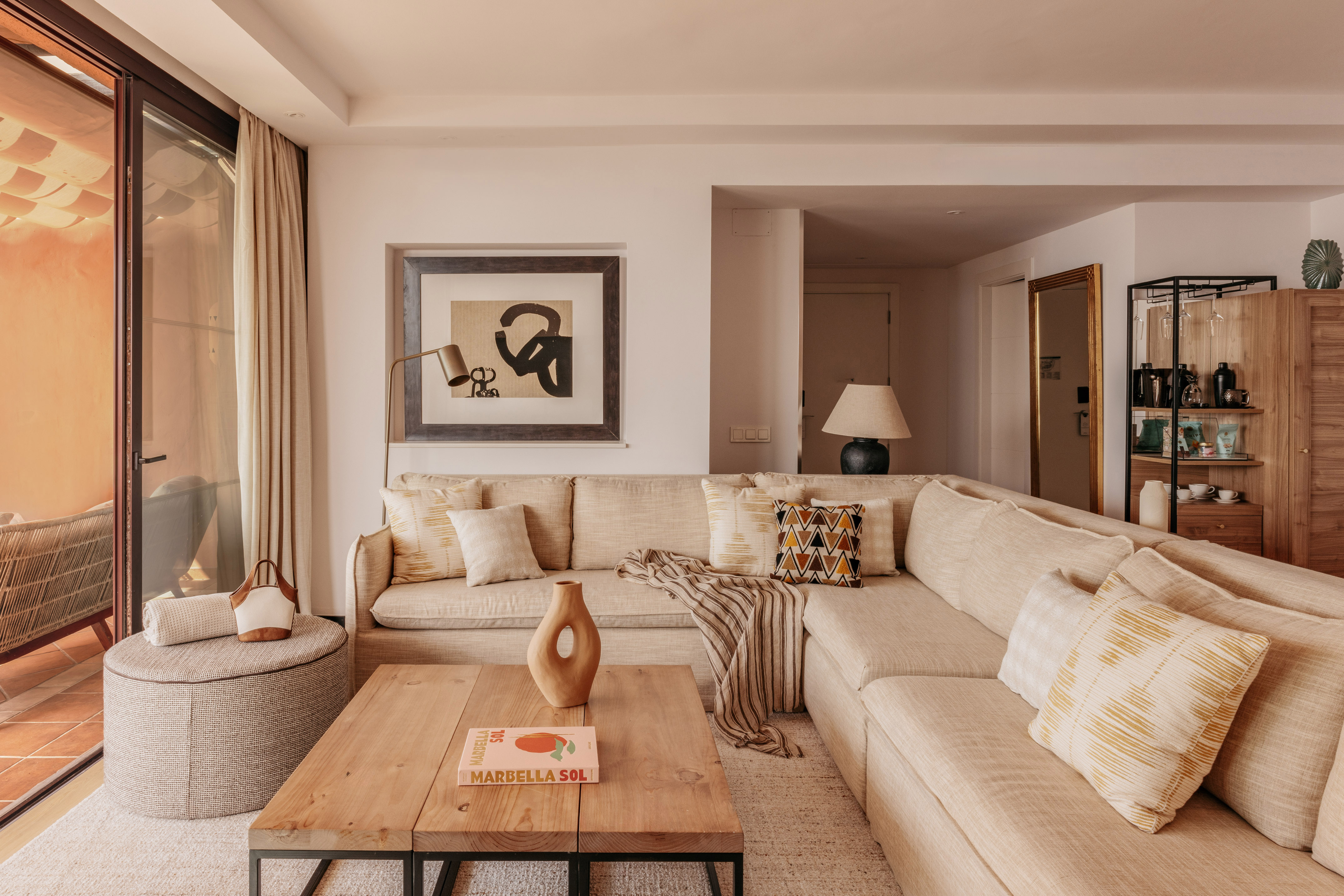 Neutral modern living room with large sectional sofa, coffee table, and art.