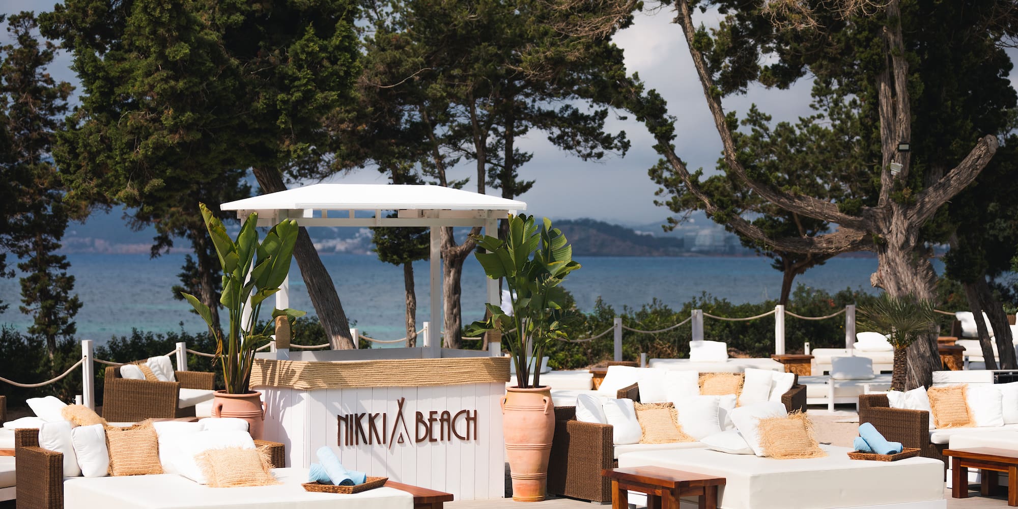 a pool with white furniture and trees