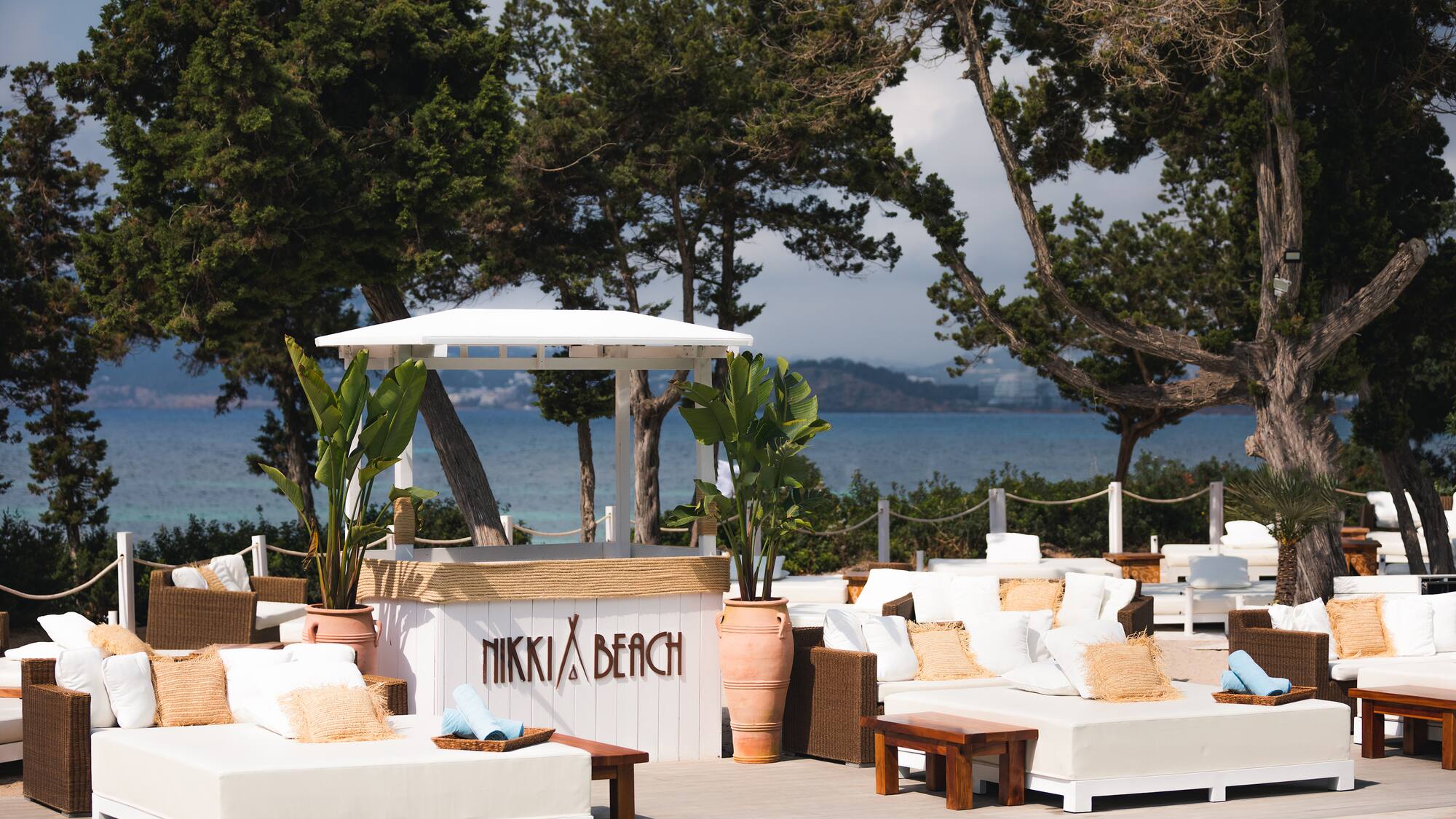 a pool with white furniture and trees