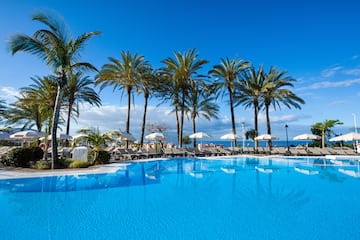 a pool with palm trees and umbrellas