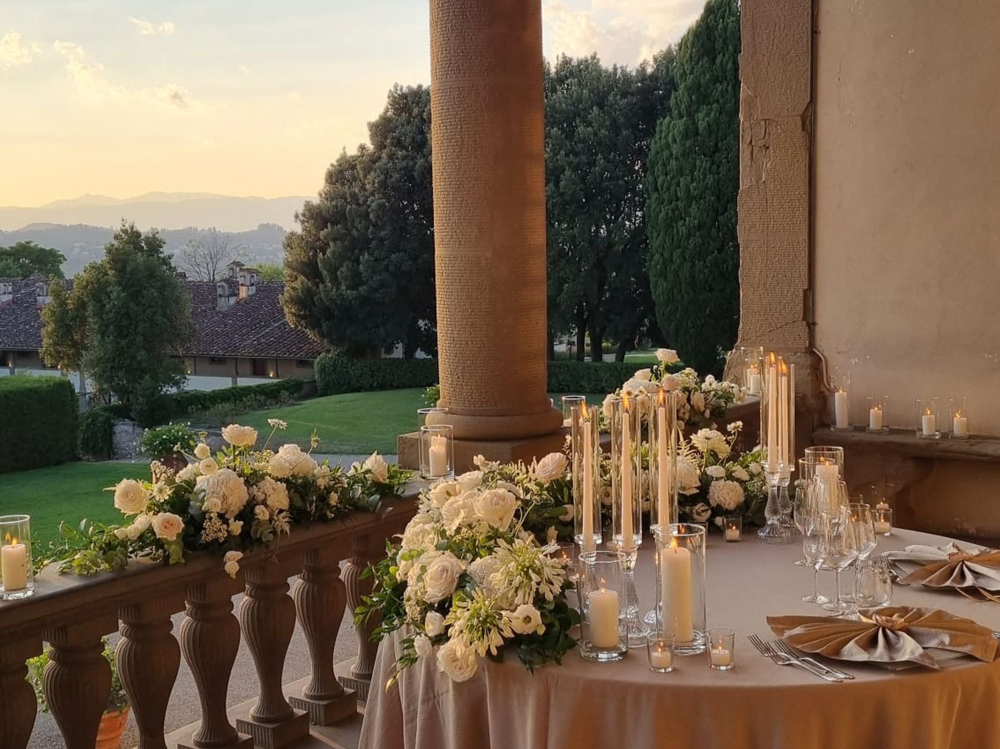 a table set up with candles and flowers on it
