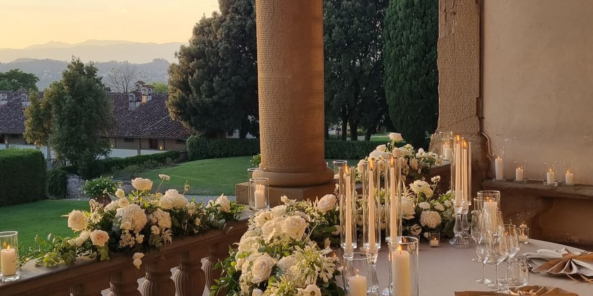 a table set up with candles and flowers on it