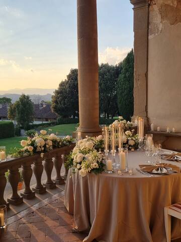 a table set up with candles and flowers on it