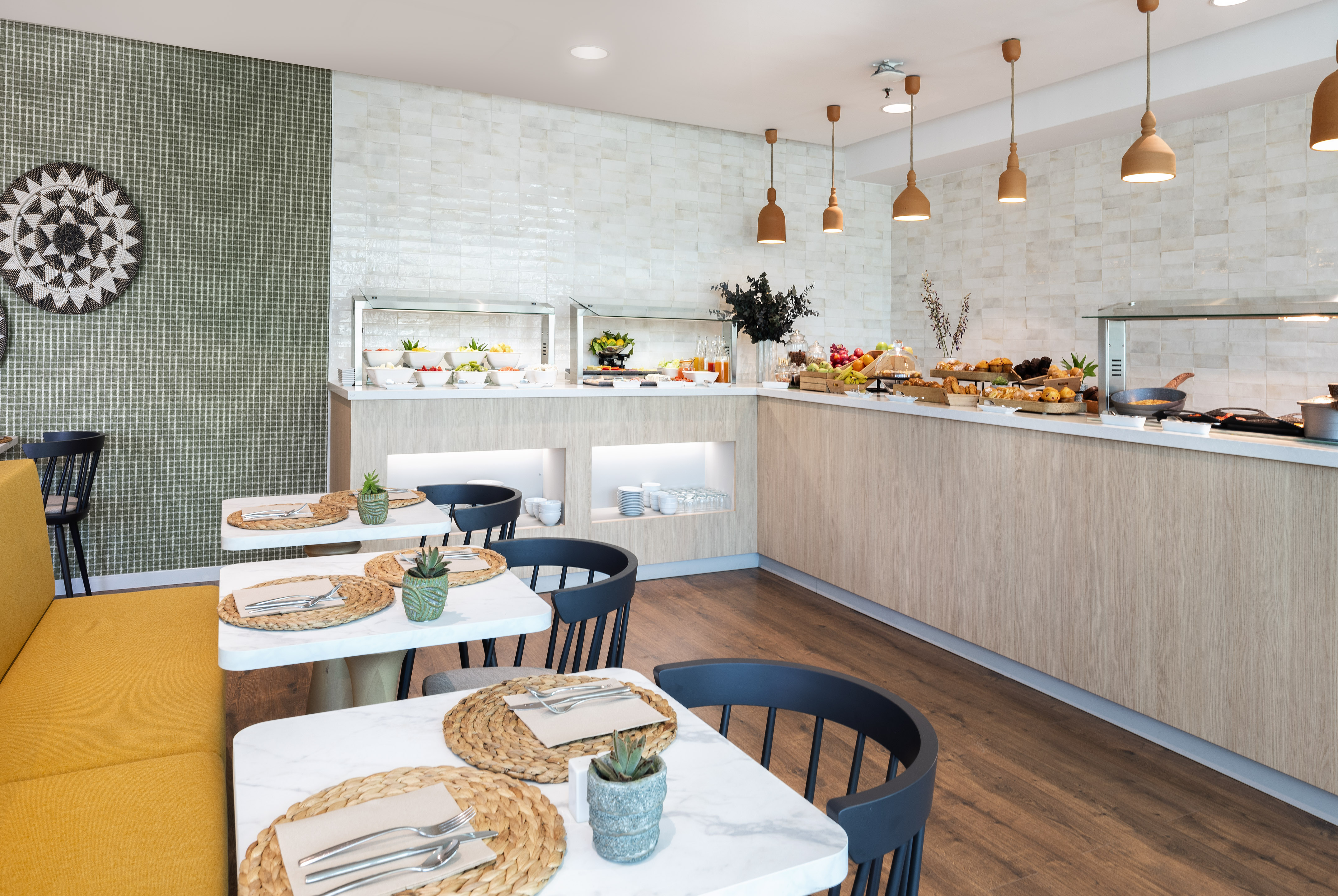 Modern buffet breakfast in a bright restaurant dining area with tables.
