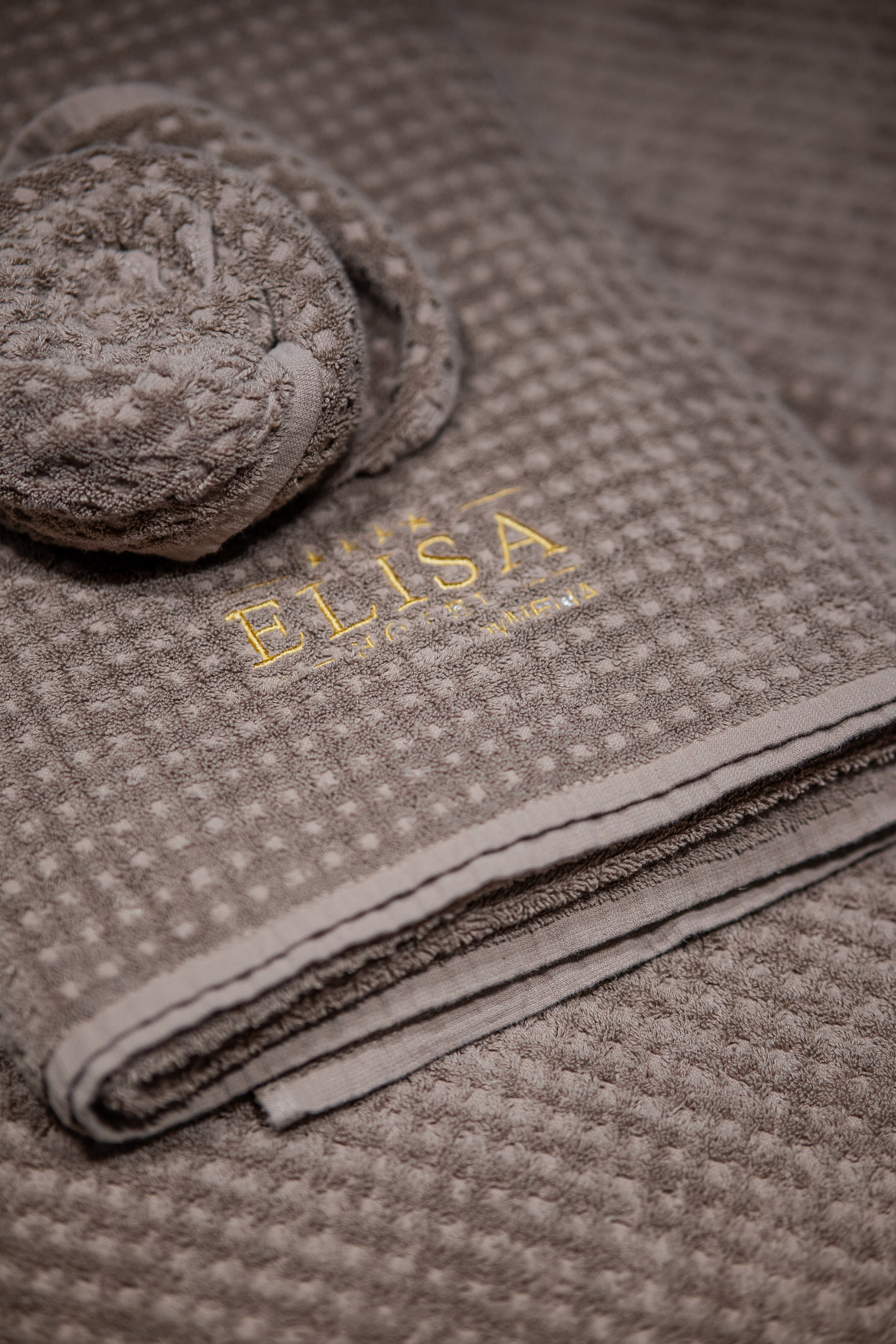 Taupe textured towel, golden ELISA embroidery, and matching washcloth.