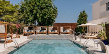 a pool with chairs and umbrellas.