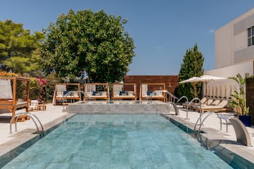 a pool with chairs and umbrellas.