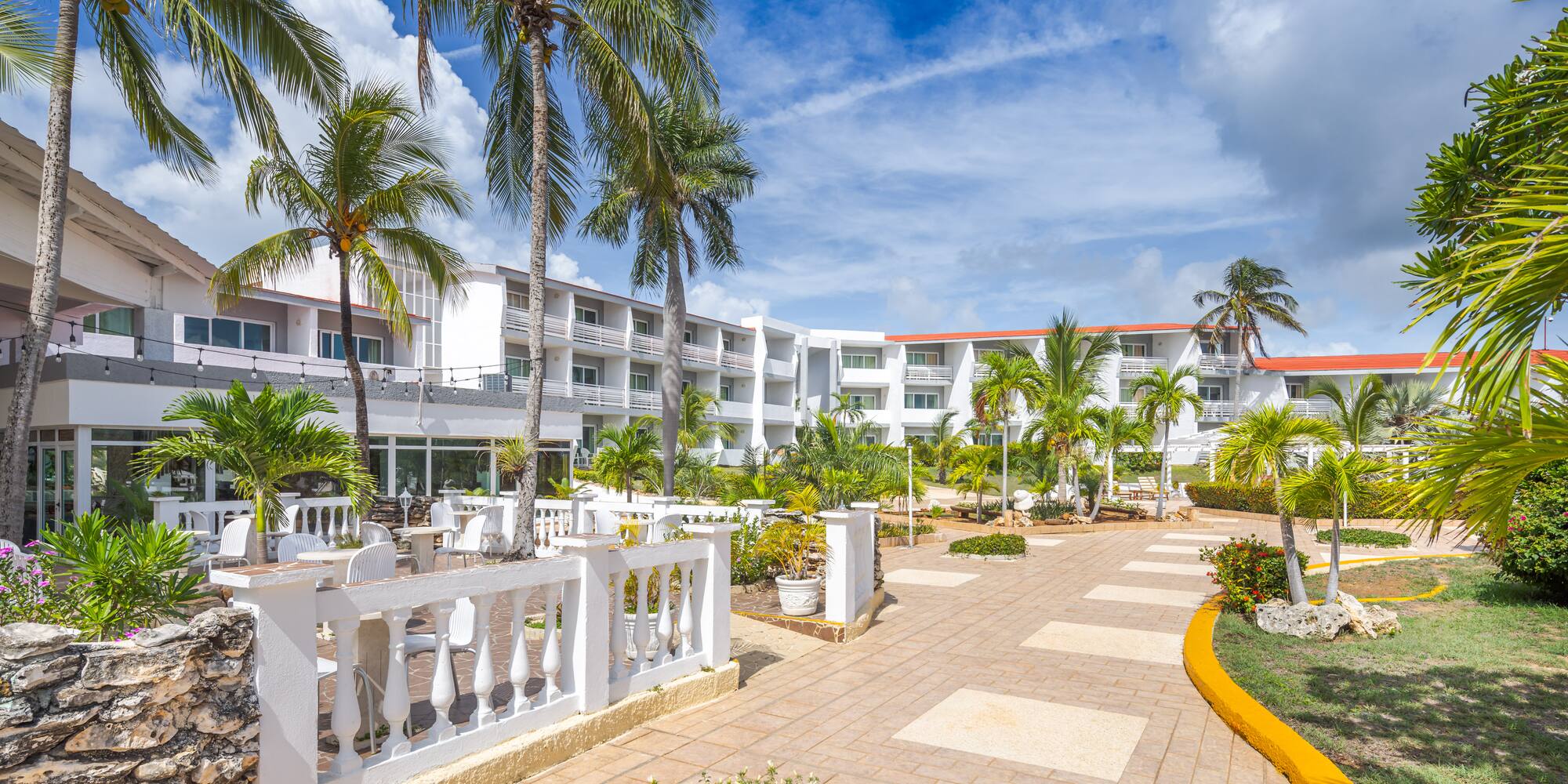 a building with palm trees and a walkway