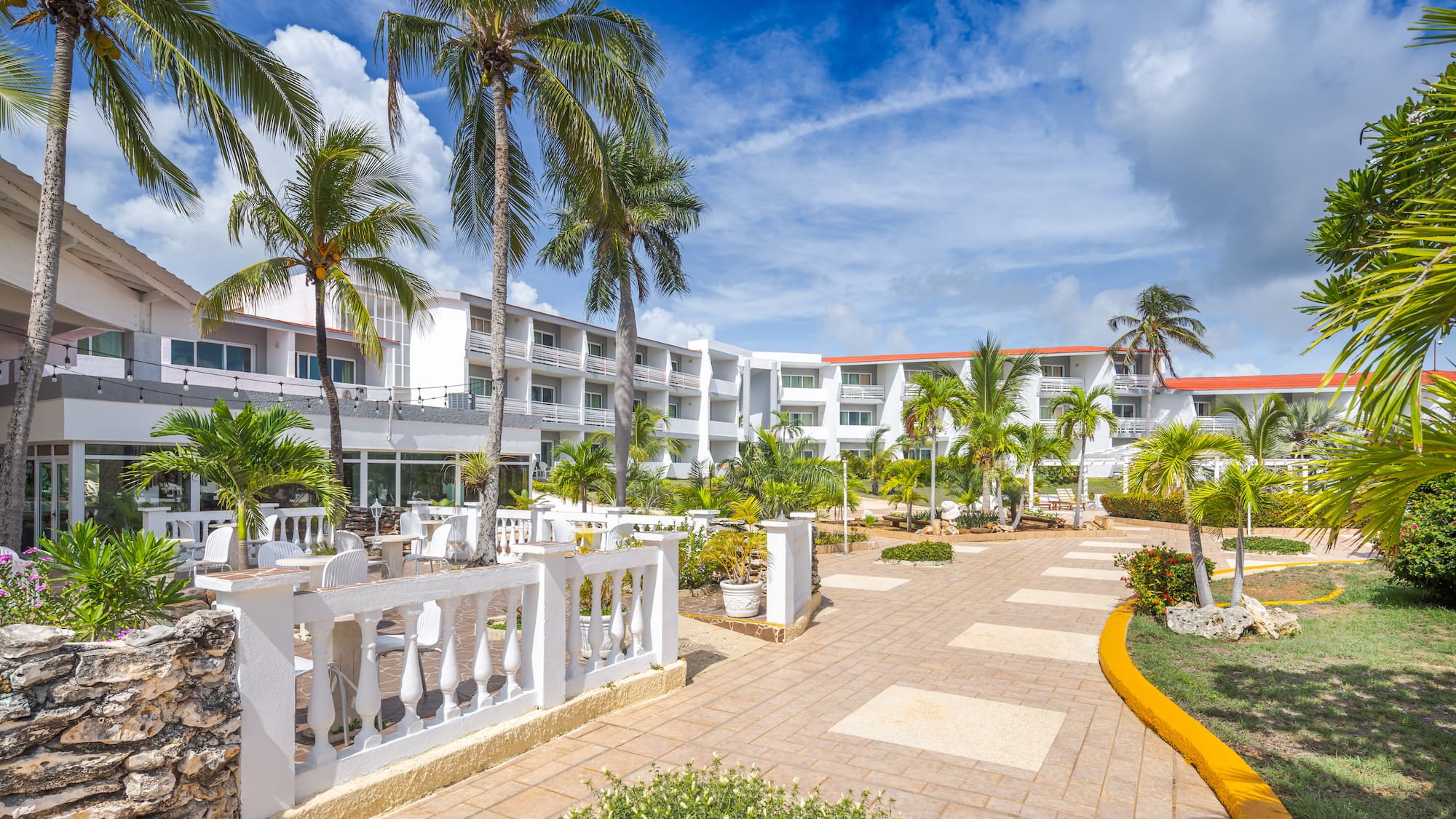 a building with palm trees and a walkway