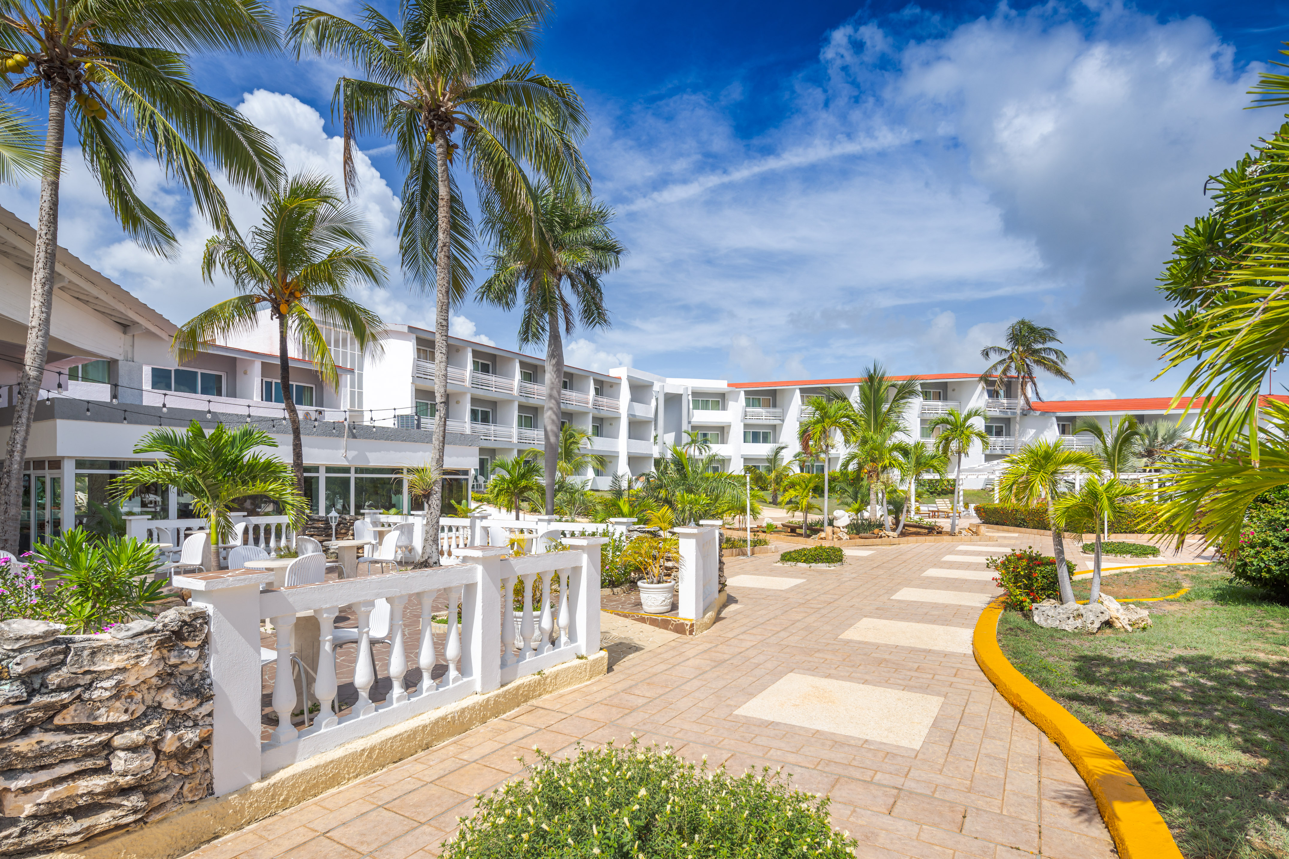 a building with palm trees and a walkway