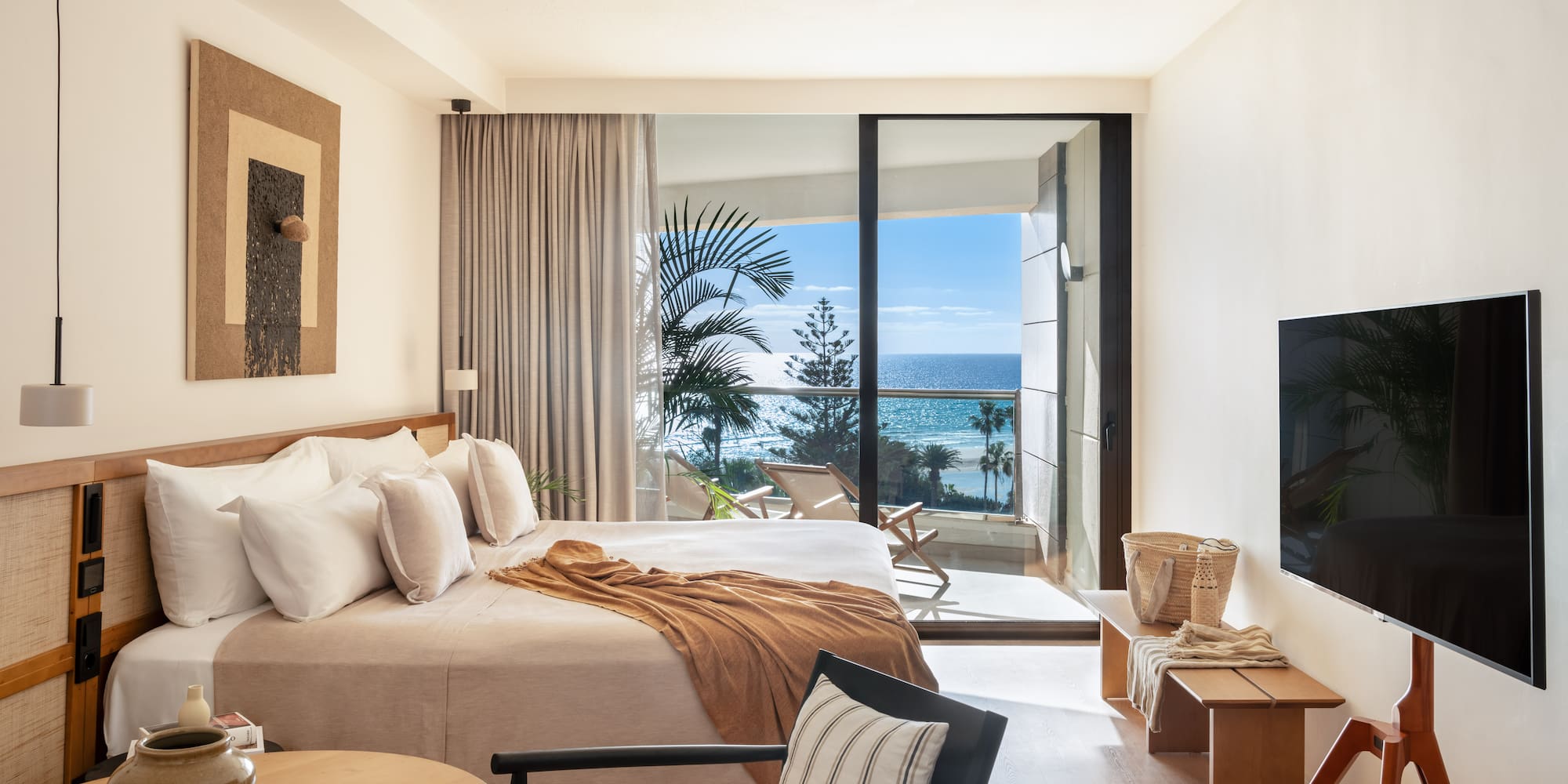 a bedroom with a large window overlooking the ocean