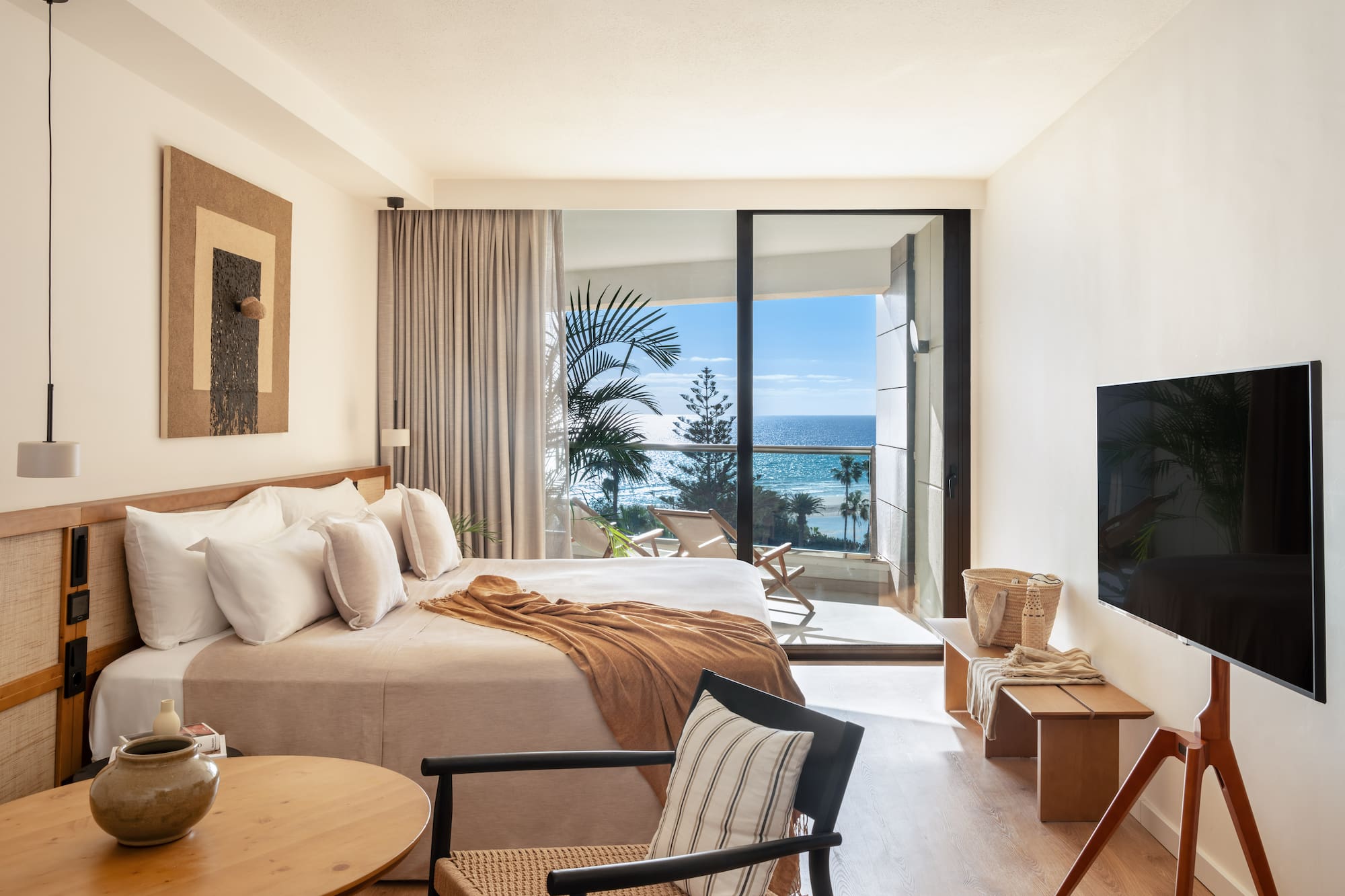 a bedroom with a large window overlooking the ocean