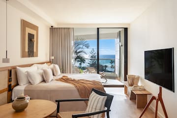 a bedroom with a large window overlooking the ocean