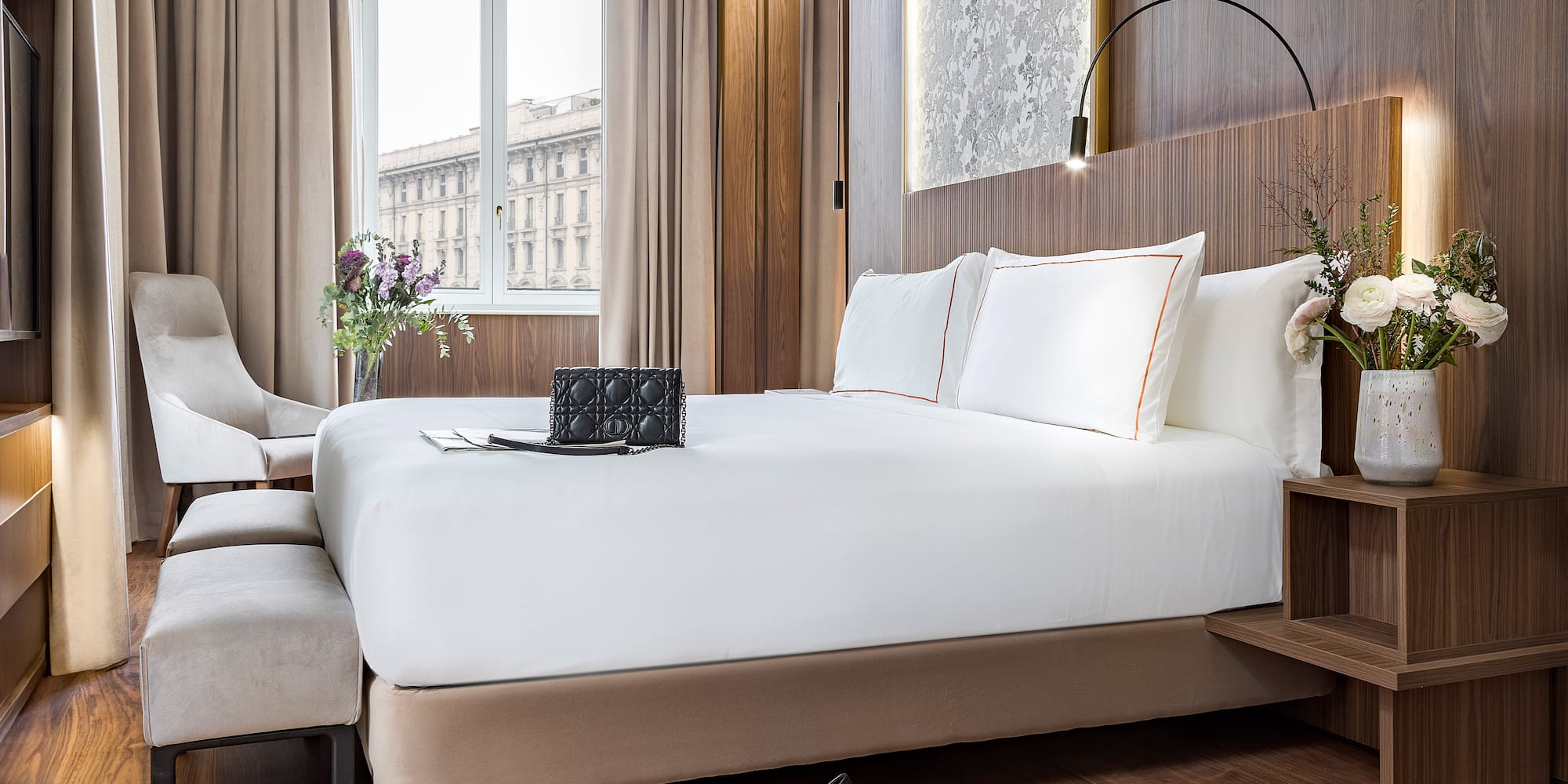 a bed with white sheets and a pair of shoes on it