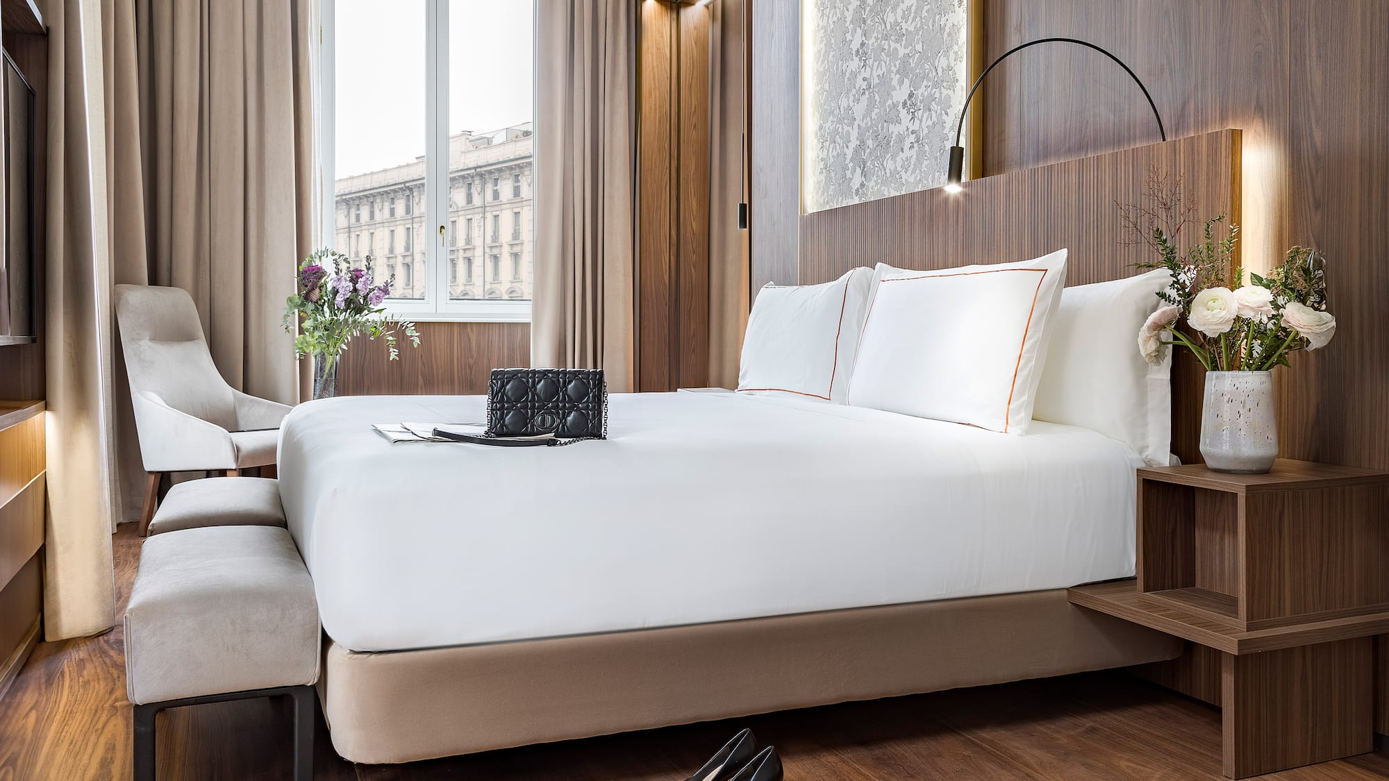 a bed with white sheets and a pair of shoes on it