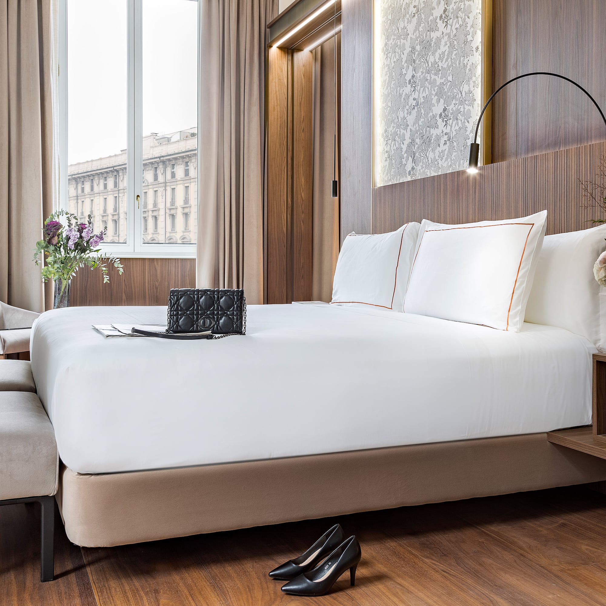 a bed with white sheets and a pair of shoes on it