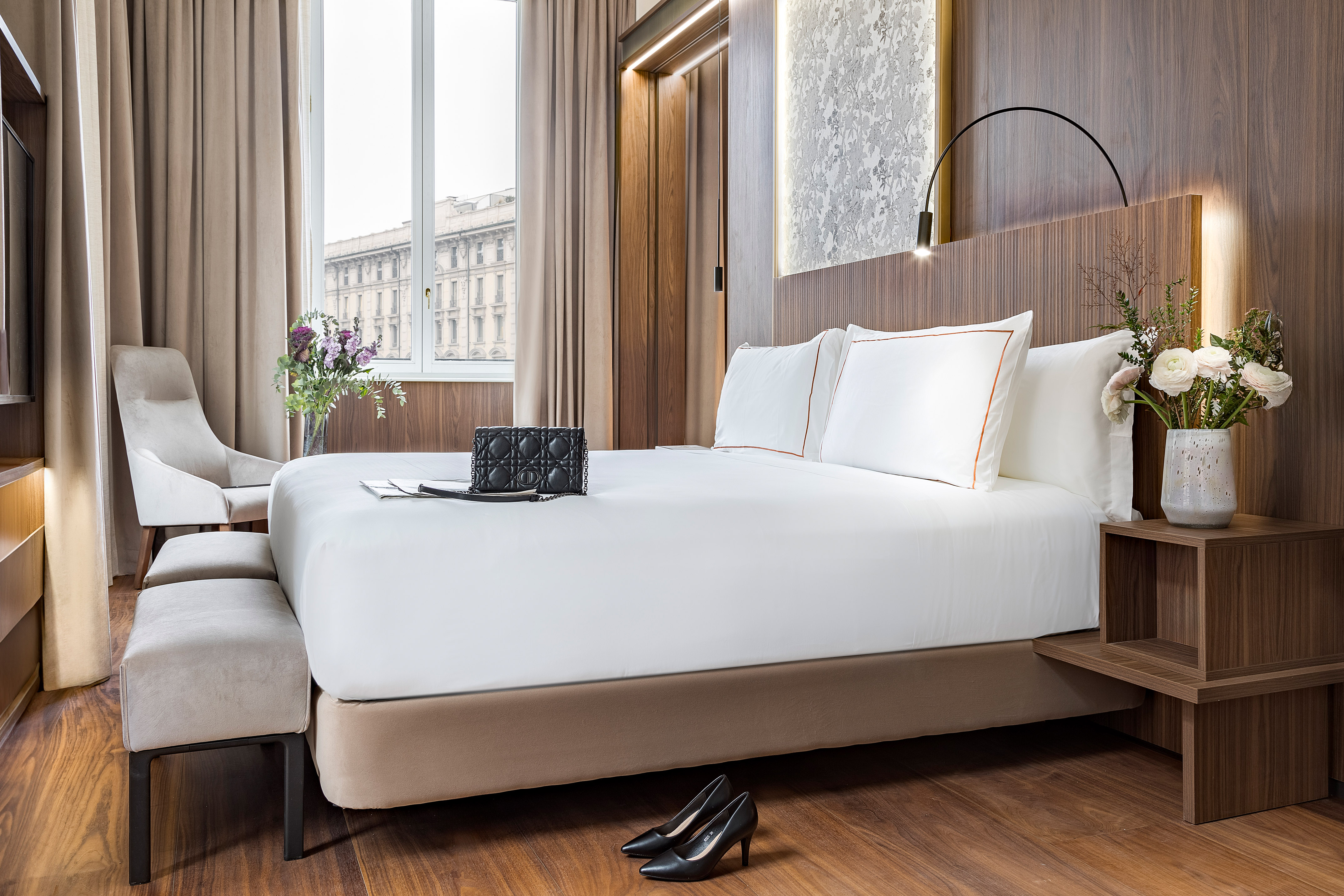 a bed with white sheets and a pair of shoes on it