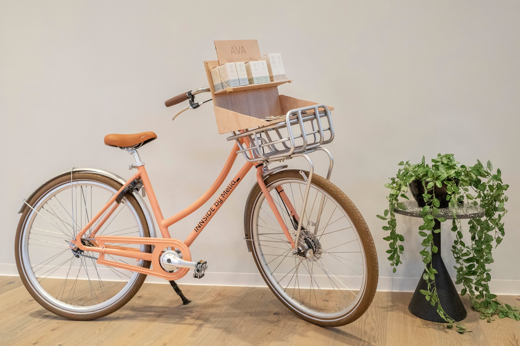 Peach INNSIDE Meliá bike with AVA skincare display in basket.