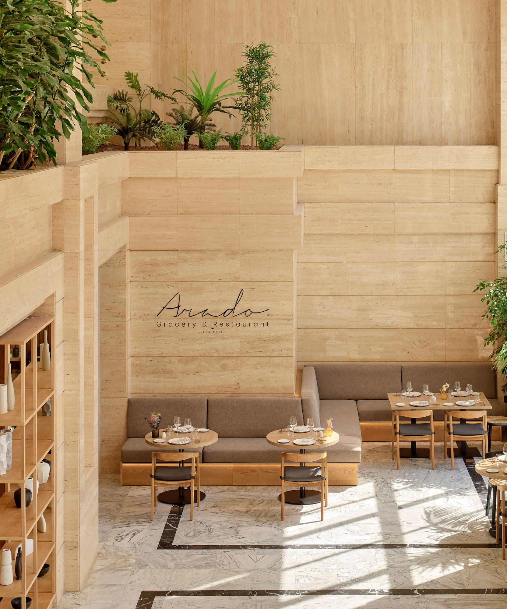 Interior moderno Arado Restaurant con plantas, madera y mármol.