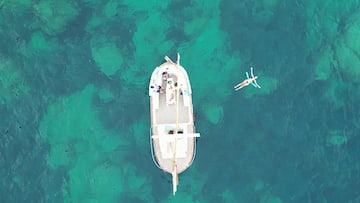 a boat in the water with people swimming