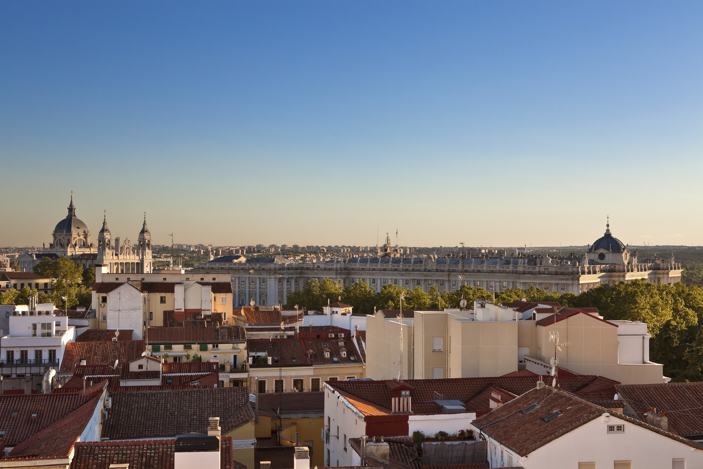 Madrid cityscape with Almudena Cathedral, Royal Palace, and red rooftops.