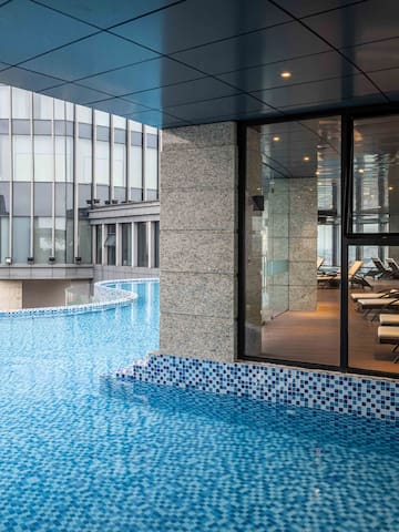 a pool with a glass wall and a building
