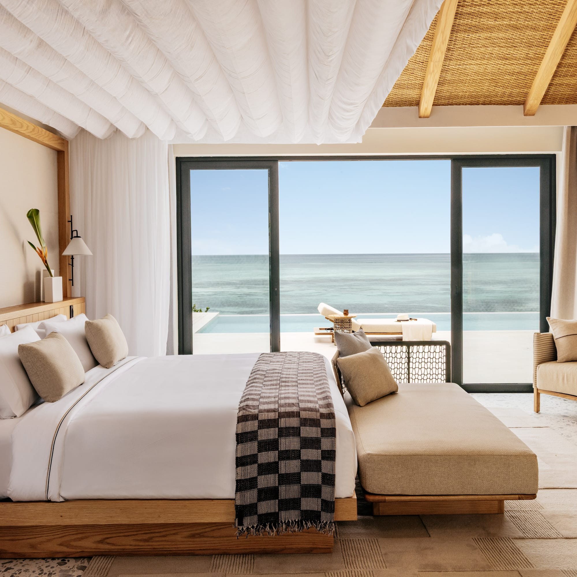 a bedroom with a large window overlooking the ocean