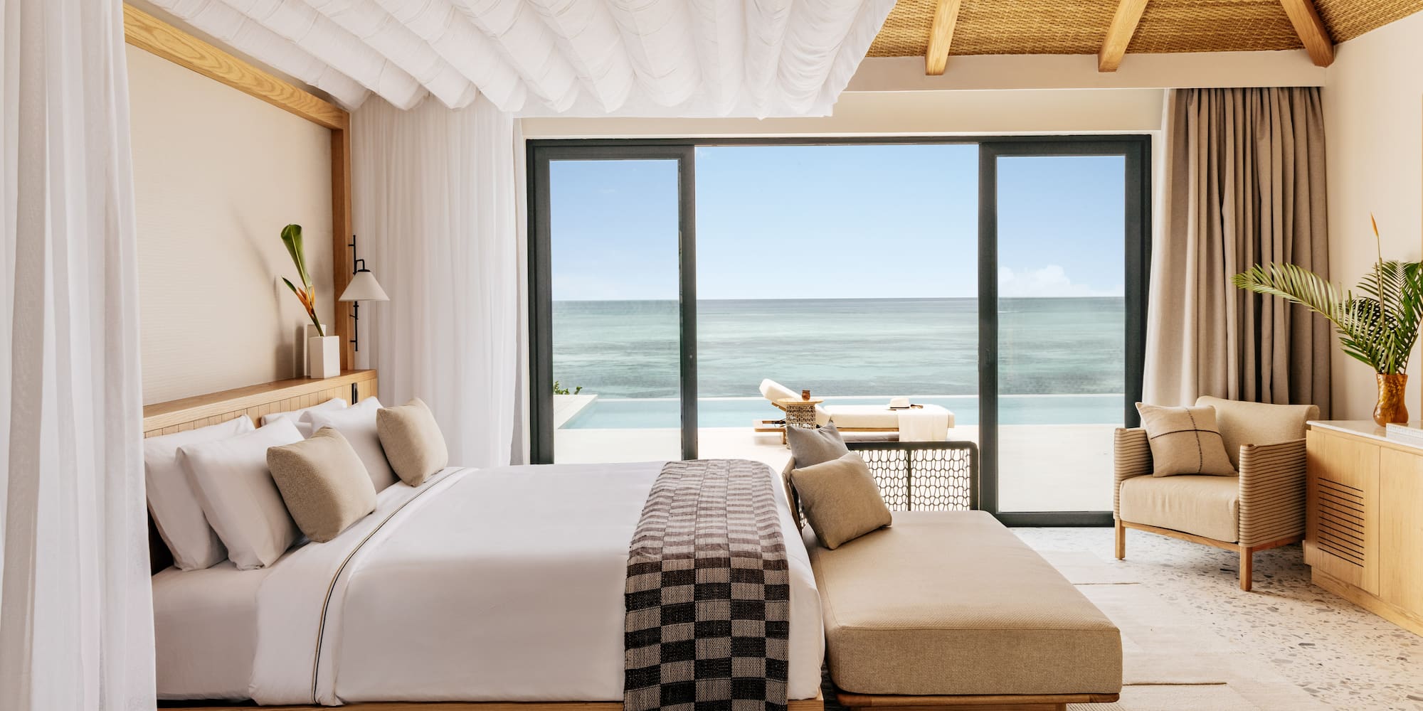 a bedroom with a large window overlooking the ocean
