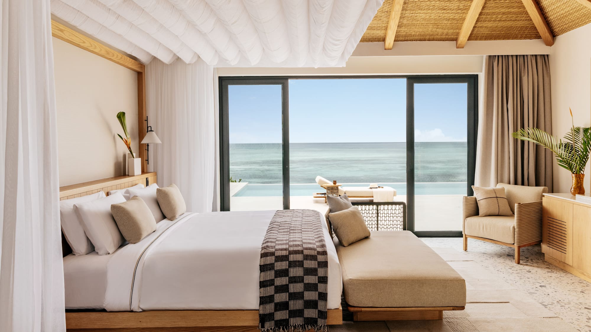 a bedroom with a large window overlooking the ocean