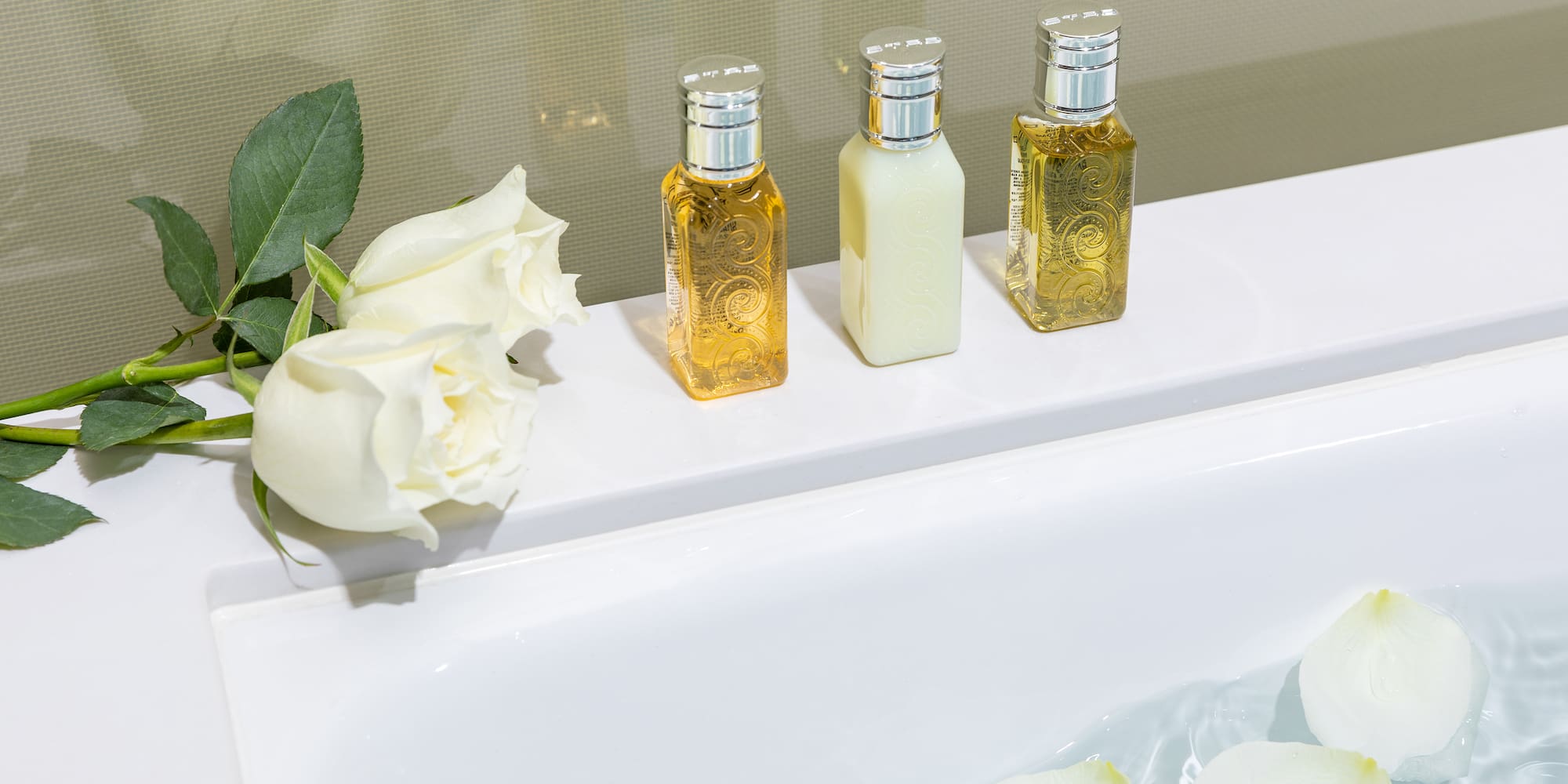 a group of bottles of liquid next to a bathtub