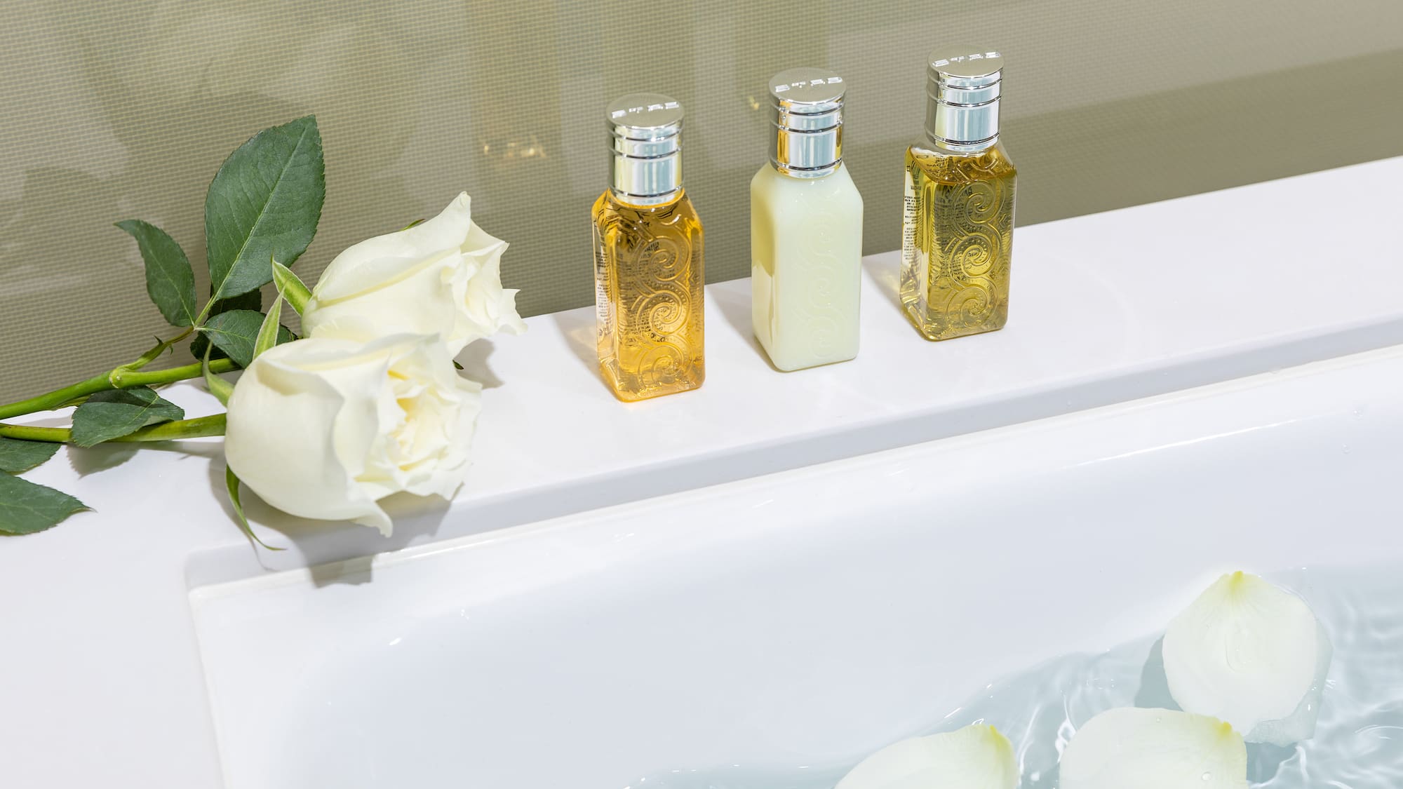 a group of bottles of liquid next to a bathtub