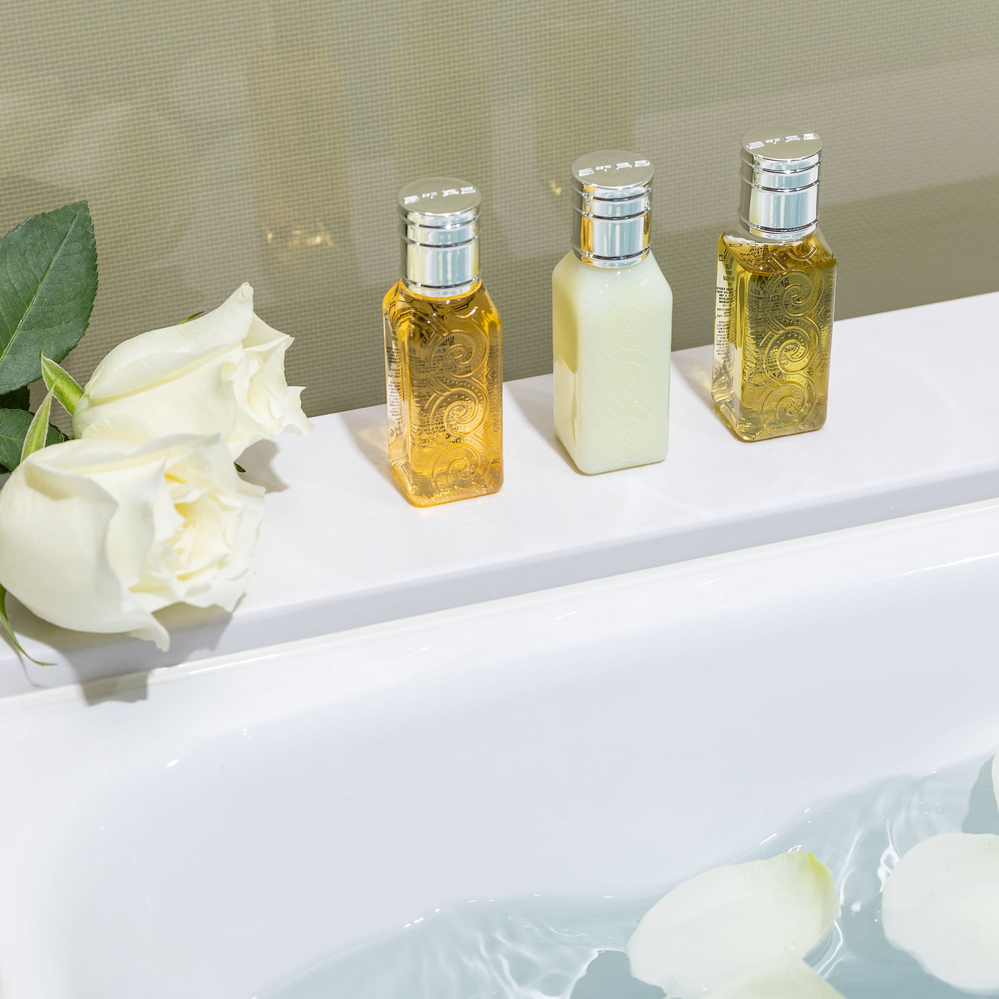 a group of bottles of liquid next to a bathtub