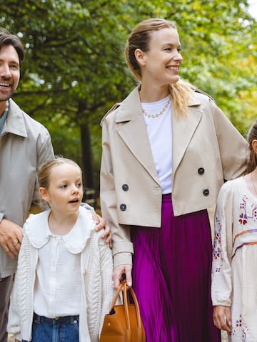 a man and woman with two children walking in a park