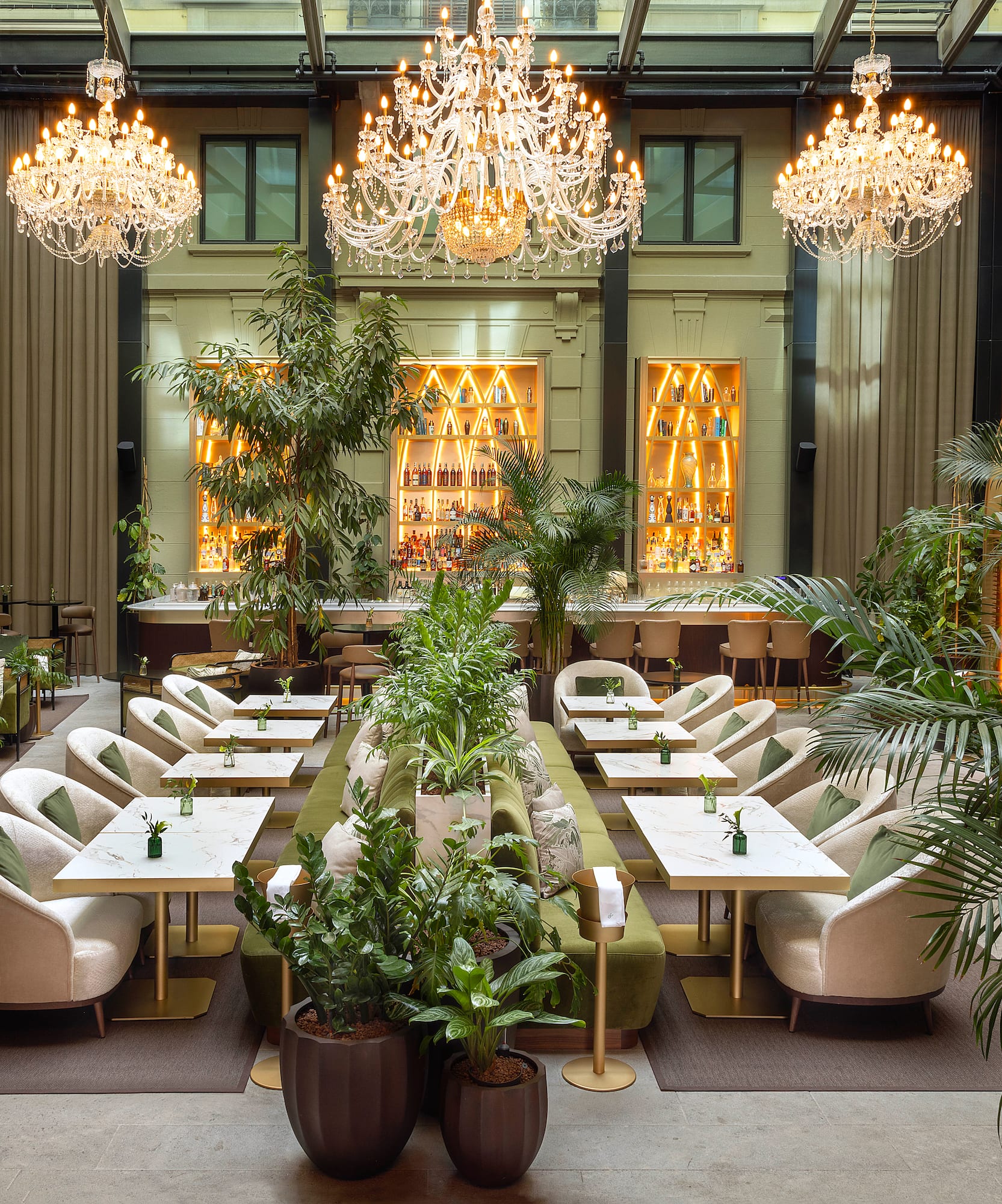 a room with tables and chairs and chandeliers