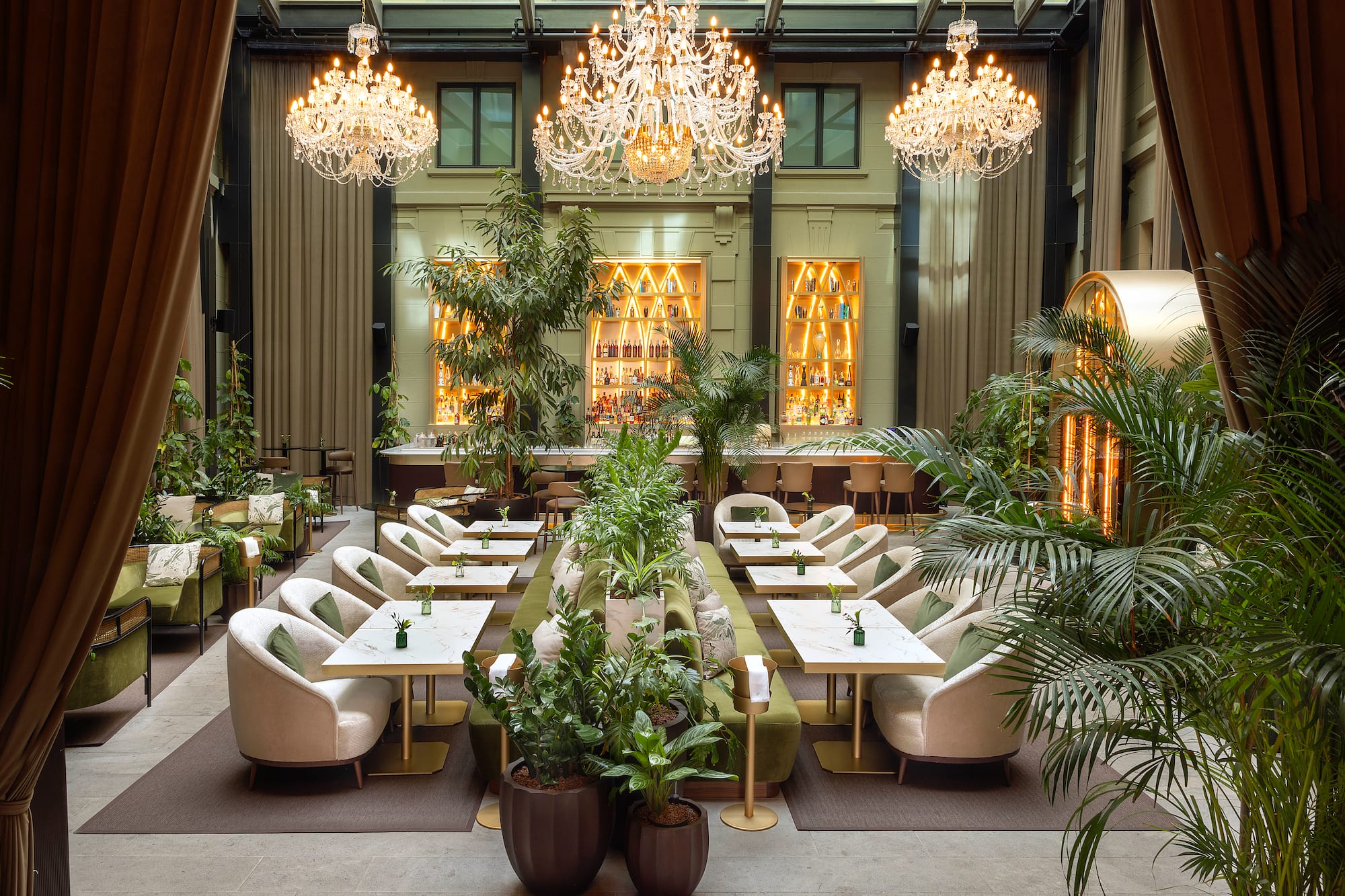 a room with tables and chairs and chandeliers