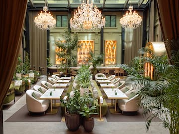 a room with tables and chairs and chandeliers