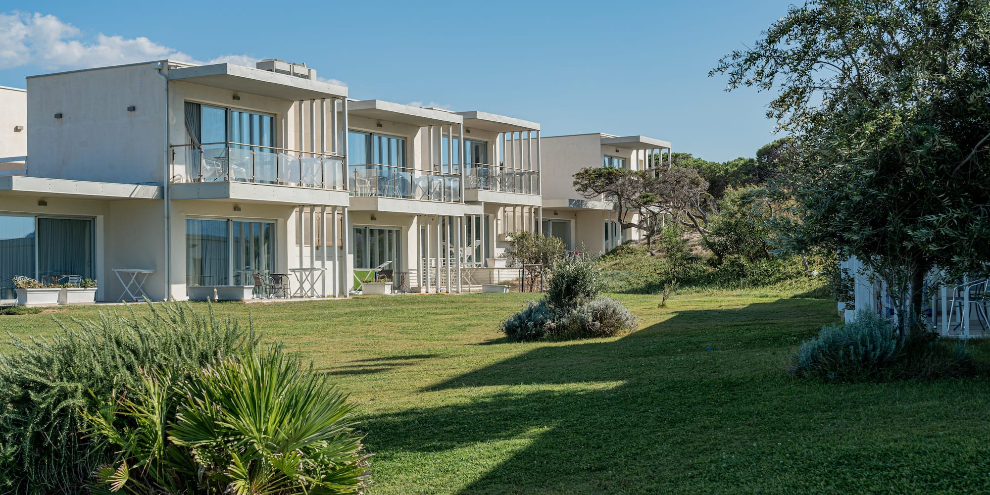 a building with balconies and grass