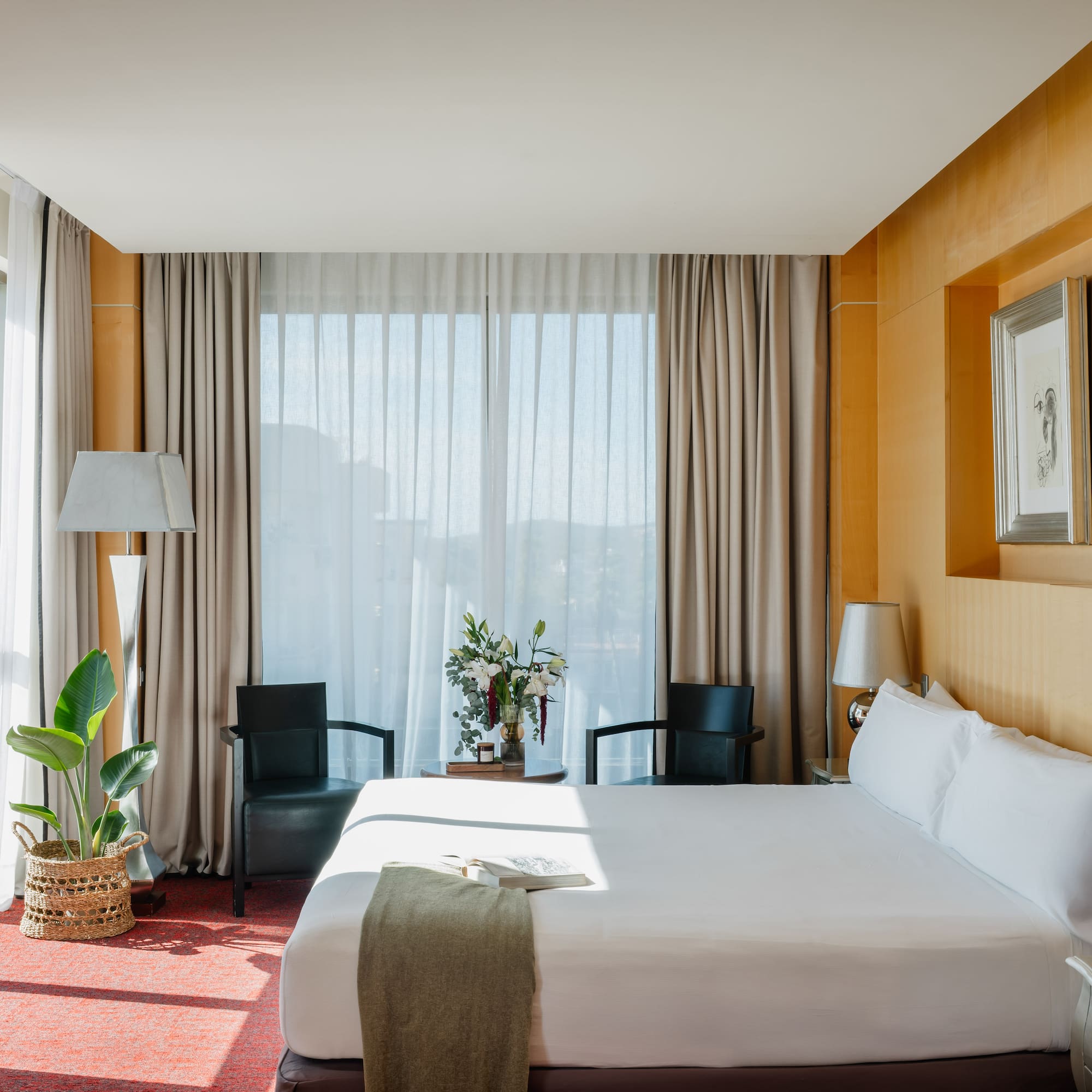 Habitación de hotel moderna, cama grande, ventanal, paneles de madera.