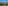 Aerial view of tropical resort, hotels, green golf course, roads, and lake.
