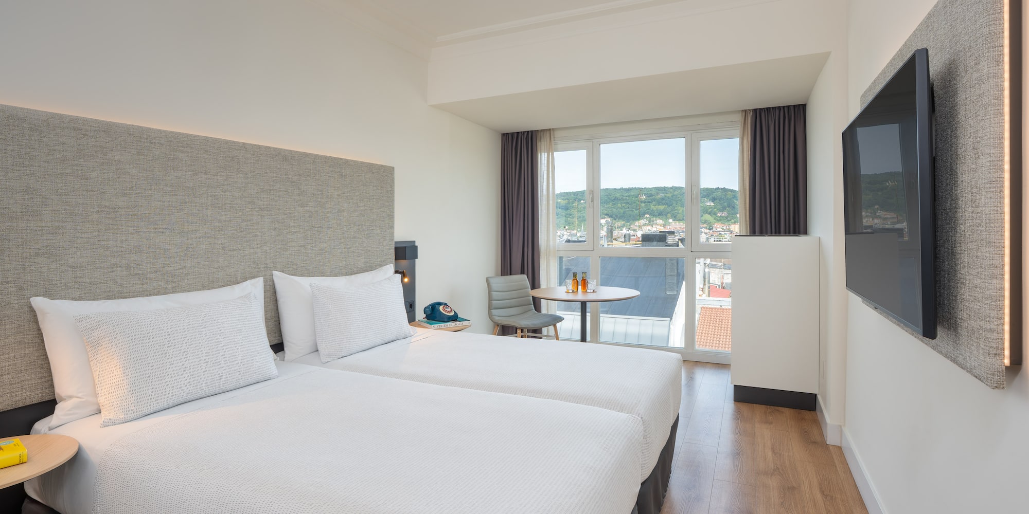 a room with two beds and a television