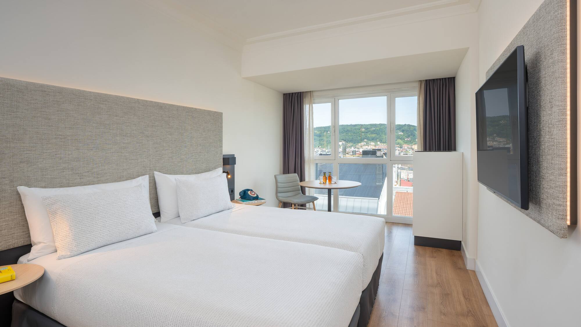 a room with two beds and a television