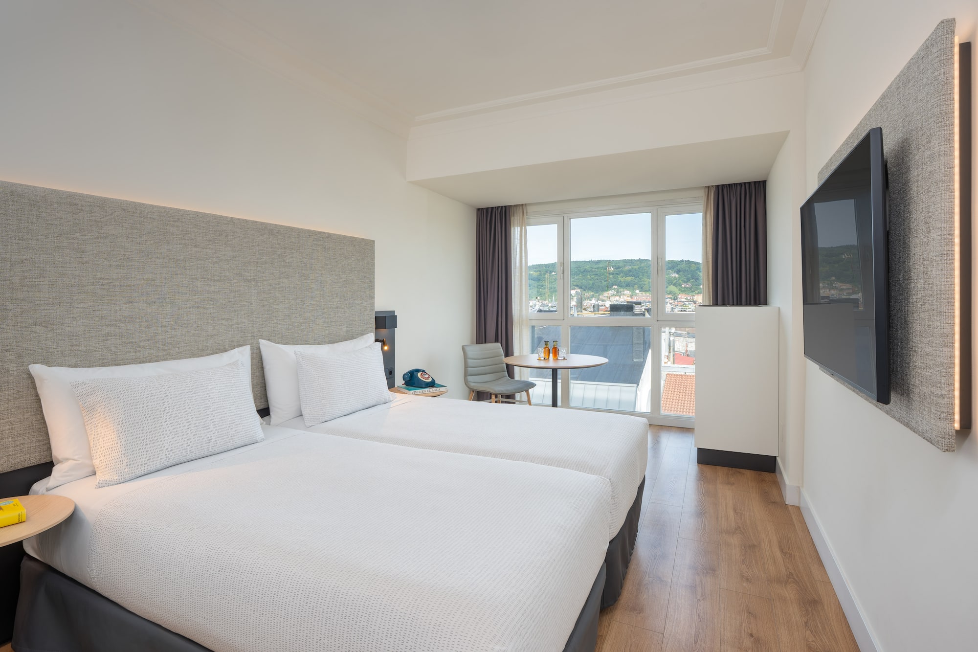 a room with two beds and a television