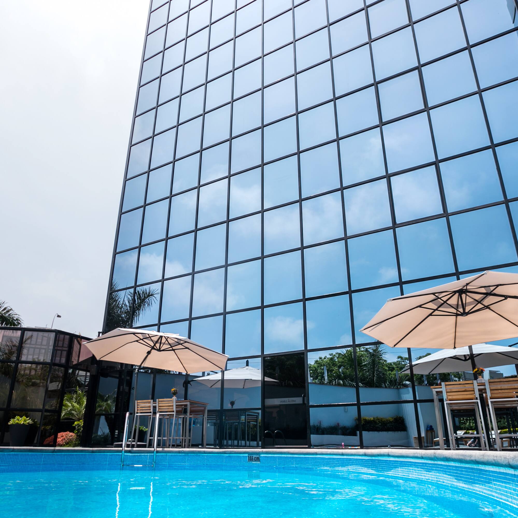 a pool with umbrellas in front of a building