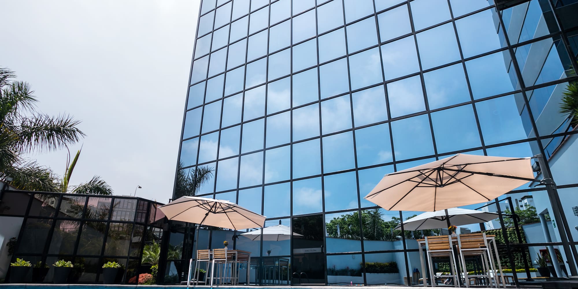 a pool with umbrellas in front of a building