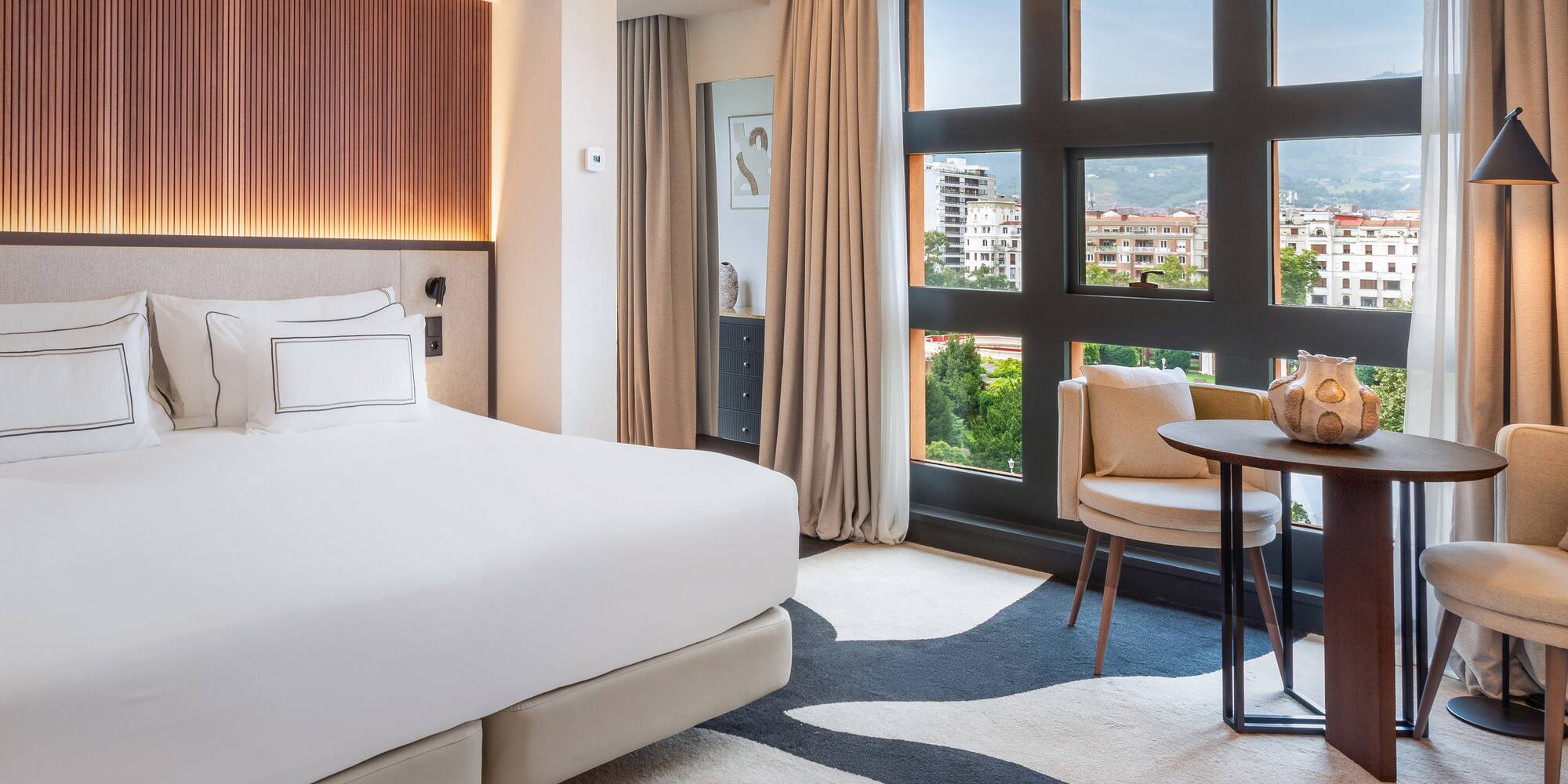 a room with a bed and a table and chairs