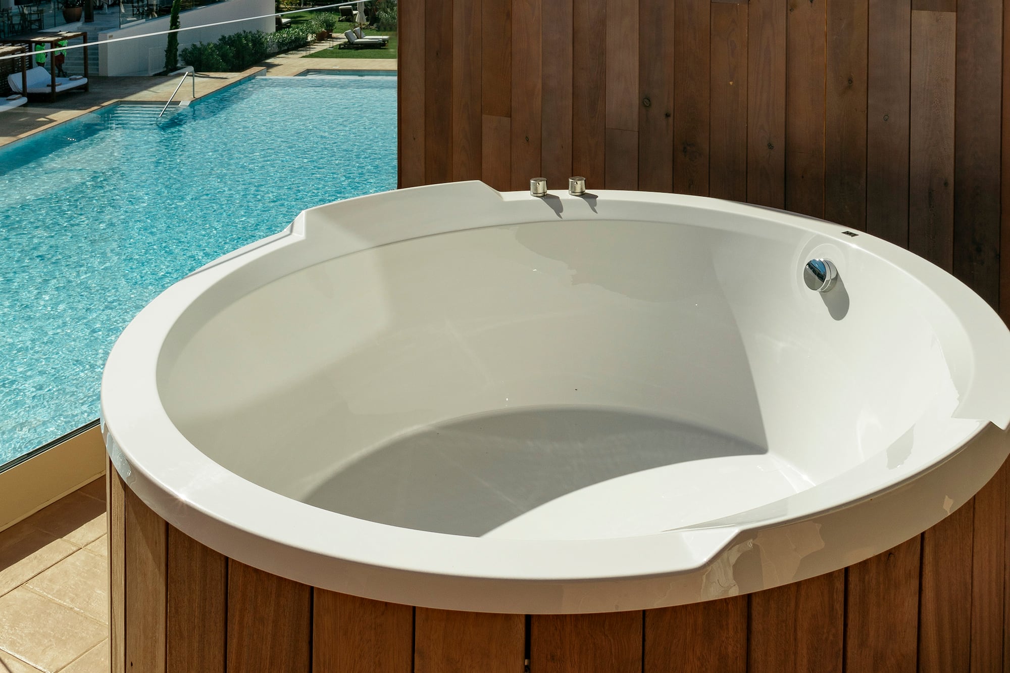 a white round tub next to a pool