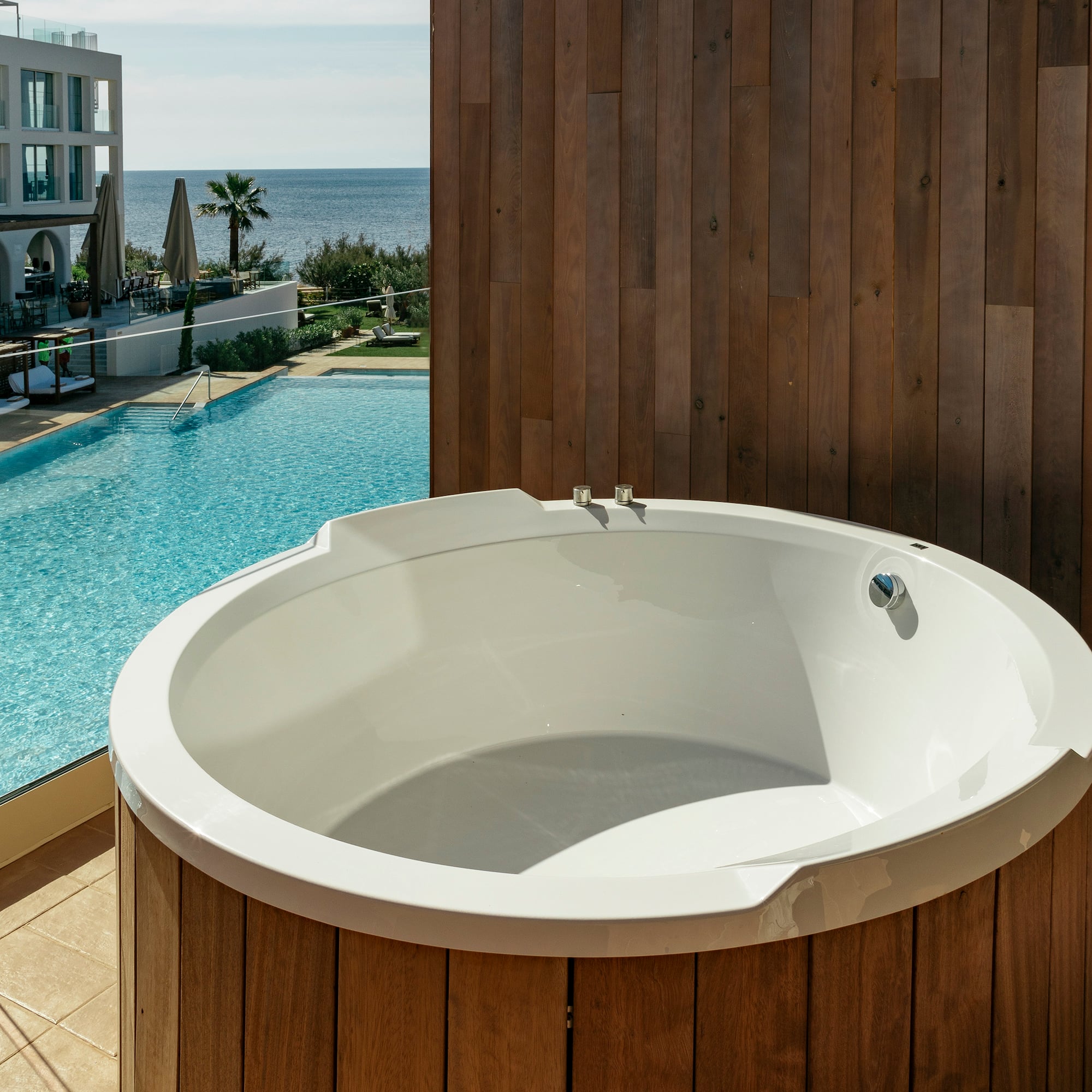 a white round tub next to a pool