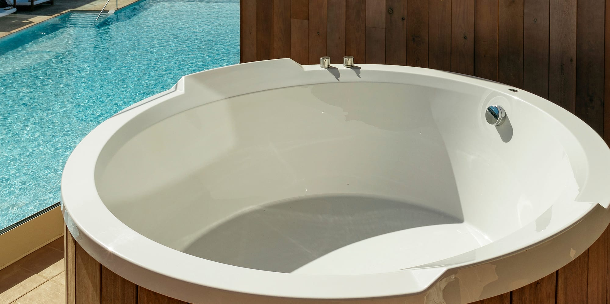 a white round tub next to a pool